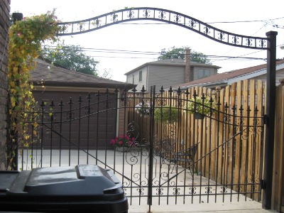 An Arched Decorative Iron Gate Adds Function and Beauty to Back Yard and Garage Access